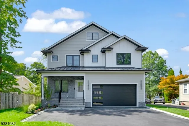 a front view of a house with a garden and garage
