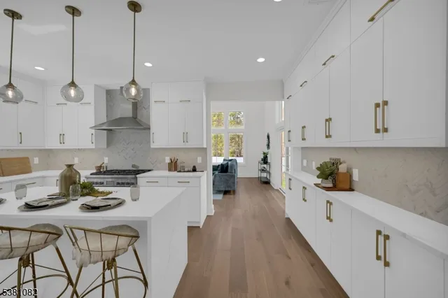 a kitchen with stainless steel appliances kitchen island a refrigerator a stove a sink and chairs