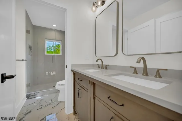 a bathroom with a granite countertop sink a toilet and a mirror