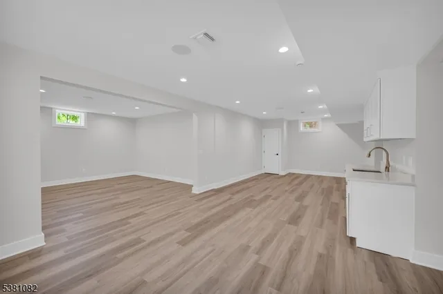 a view of a kitchen with a sink and wooden floor