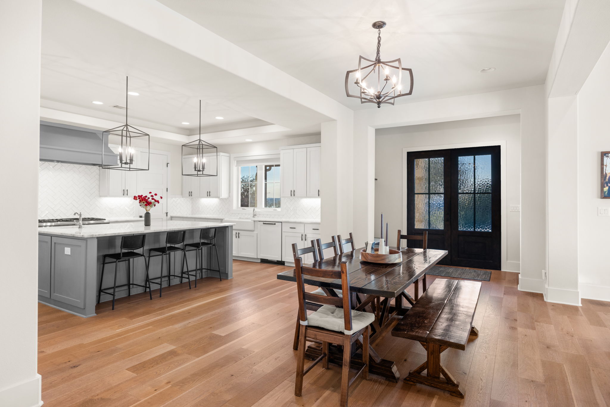 7809 Brandy Way Volente, TX 78641 - Photo 12 of 40 a dining room with wooden floor a chandelier a wooden table and chairs