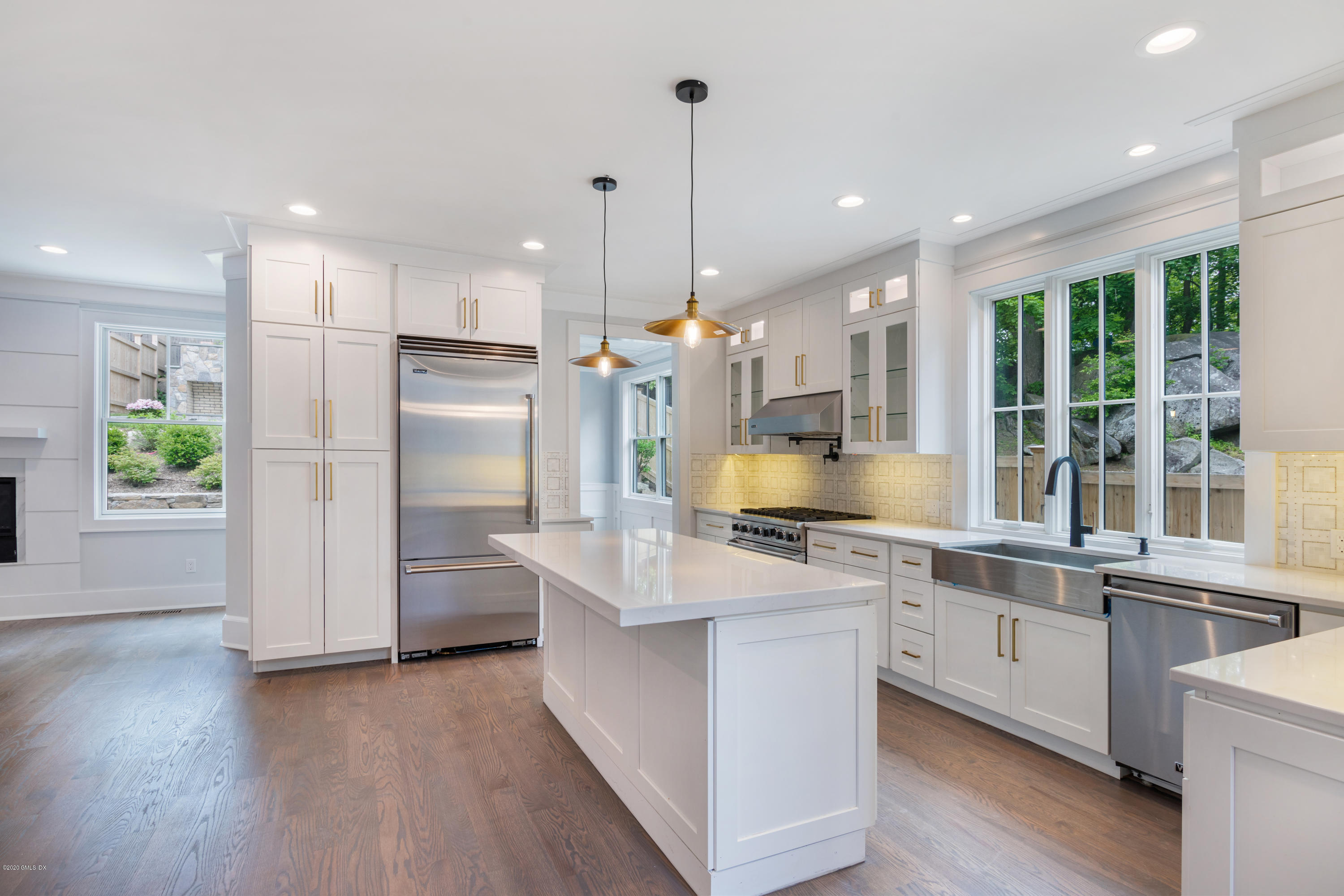 38 Cassidy Street, Unit 38 Greenwich, CT 06830 - Photo 10 of 50 a kitchen with kitchen island a stove a sink a refrigerator and a dining table with wooden floor