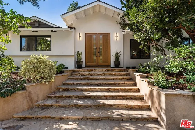 a front view of a house with a garden