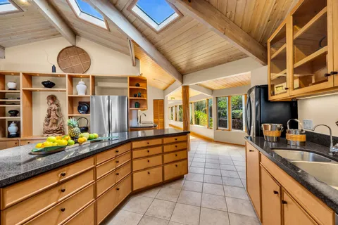a large kitchen with a large window and stainless steel appliances