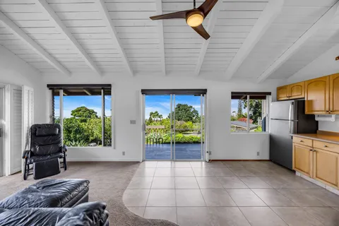 a living room with furniture ceiling fan and a large window