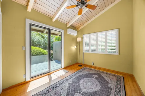 a view of a patio with table and chairs potted plants and floor to ceiling window