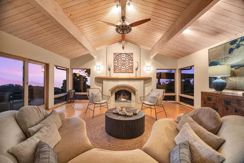 a living room with furniture a fireplace and a ceiling fan