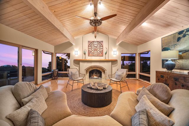 a living room with furniture a fireplace and a ceiling fan