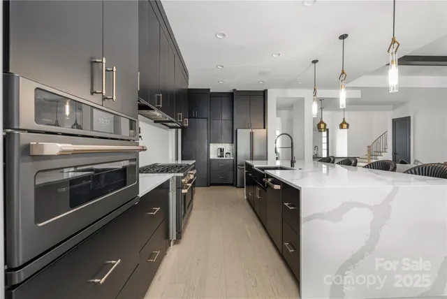 a kitchen with stainless steel appliances a stove sink and cabinets