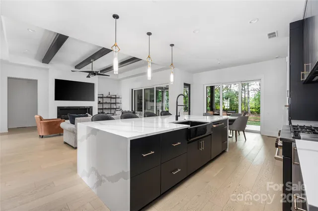 a large kitchen with kitchen island a counter space a sink a window and stainless steel appliances