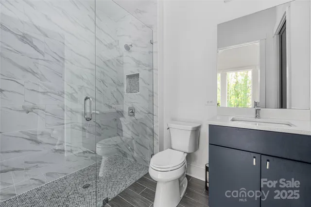 a bathroom with a sink a toilet and shower