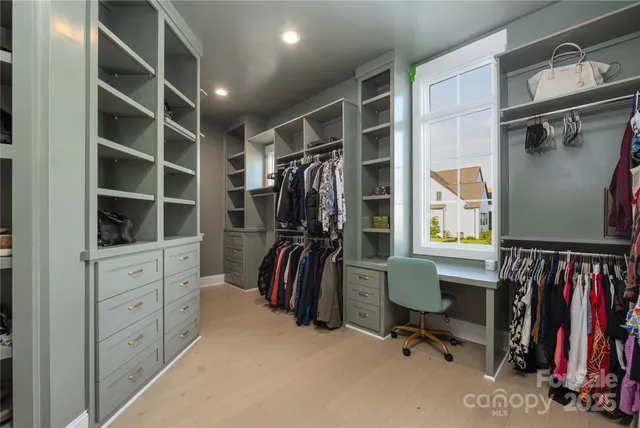 a view of walk in closet with clothes and shoes