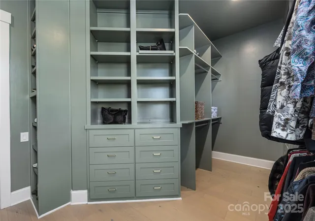 a view of walk in closet with clothes and shoes