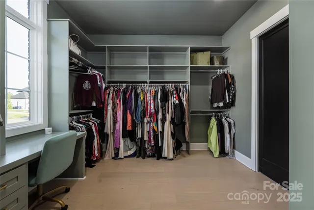 a view of walk in closet with clothes and shoes
