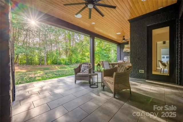 a view of a patio with table and chairs next to a yard