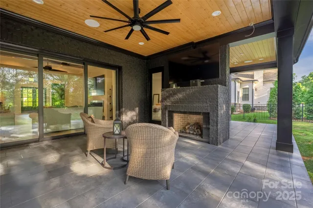 a living room with furniture a fireplace and a floor to ceiling window