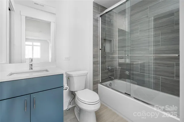 a bathroom with a bathtub shower sink mirror and toilet