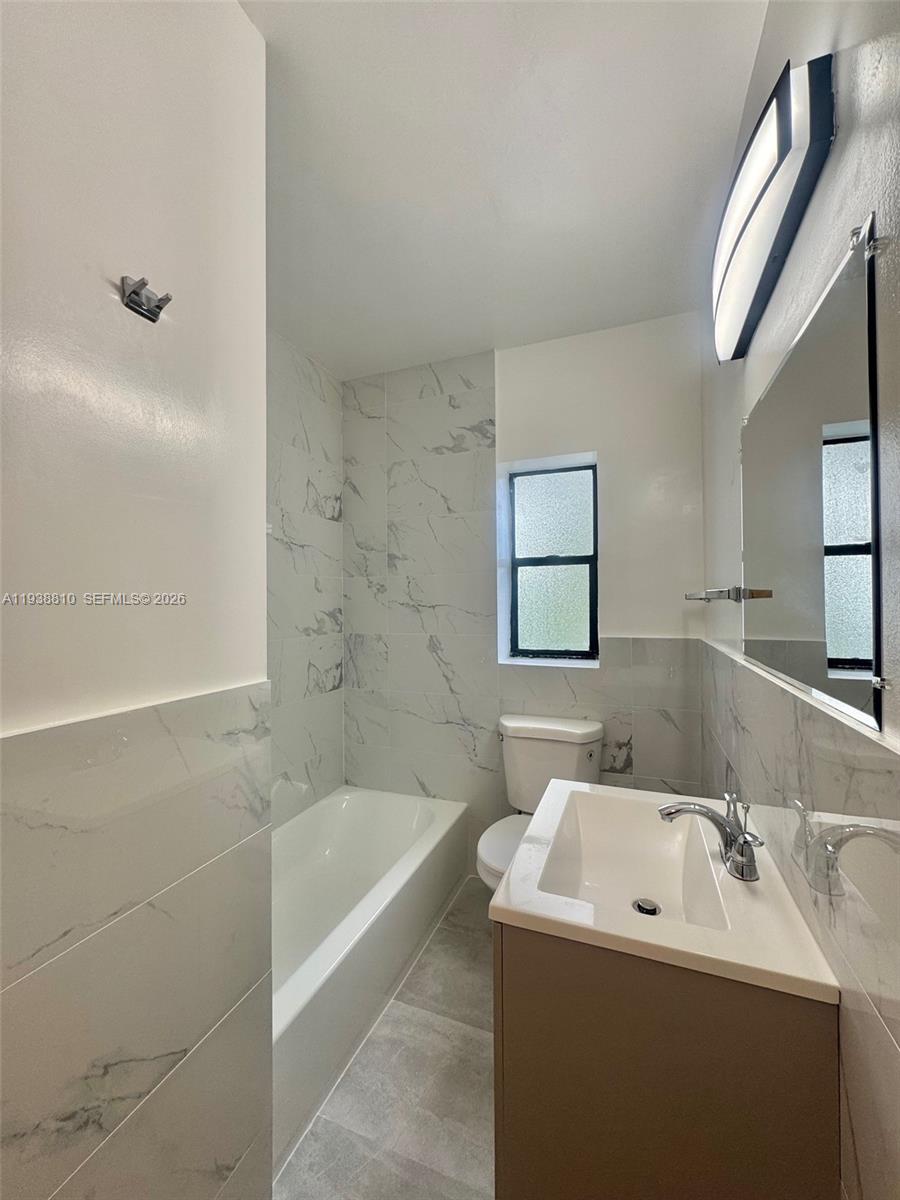 530 Northeast 71st Street, Unit 2 Miami, FL 33138 - Photo 14 of 22 a bathroom with a sink a toilet and shower