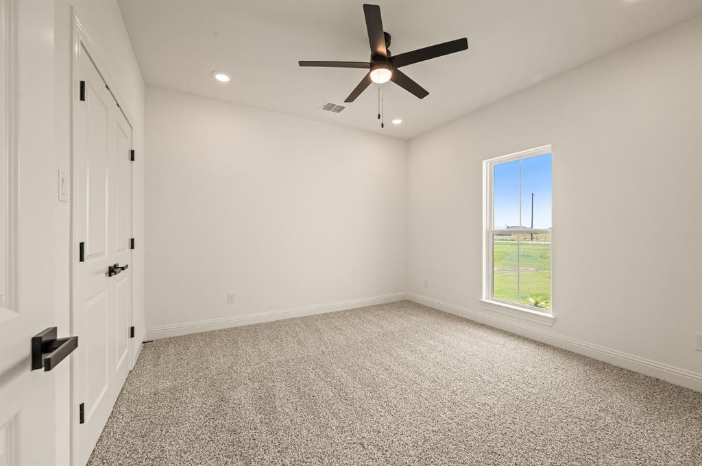 2705 Gospel Road Tolar, TX 76476 - Photo 23 of 36 Carpeted room featuring a ceiling fan with integrated lighting, recessed lighting, a single window, white baseboards, and white paneled doors with matte black hardware