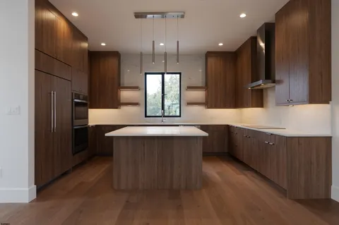 a kitchen with kitchen island a counter top and refrigerator
