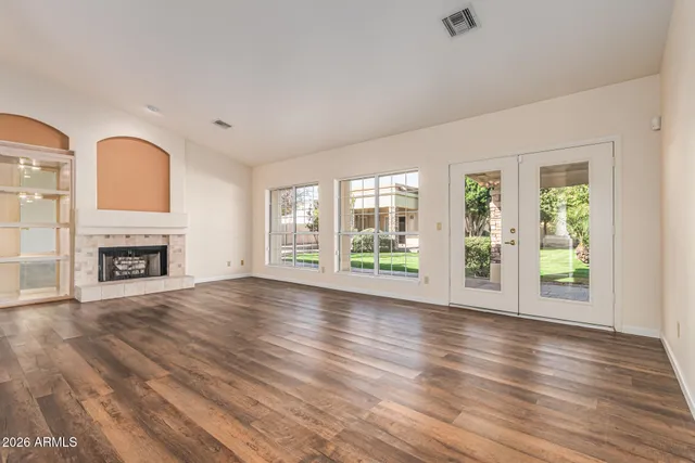 a kitchen with stainless steel appliances granite countertop a kitchen island a stove a refrigerator cabinets and wooden floor