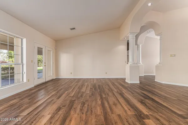 a kitchen with stainless steel appliances granite countertop a kitchen island a stove a refrigerator cabinets and wooden floor
