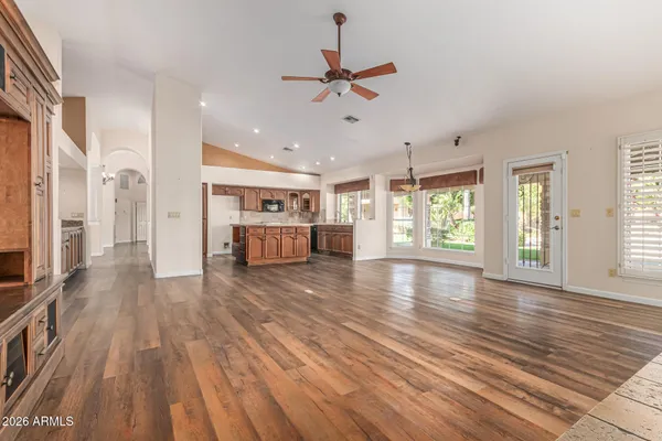 a view of a room with a ceiling fan a kitchen and a window