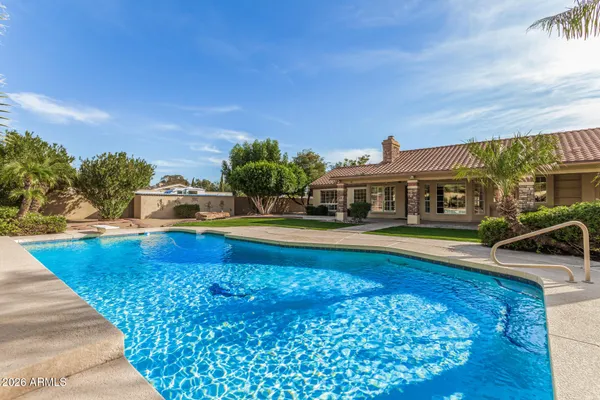 a bathroom with a granite countertop sink a toilet a mirror and shower