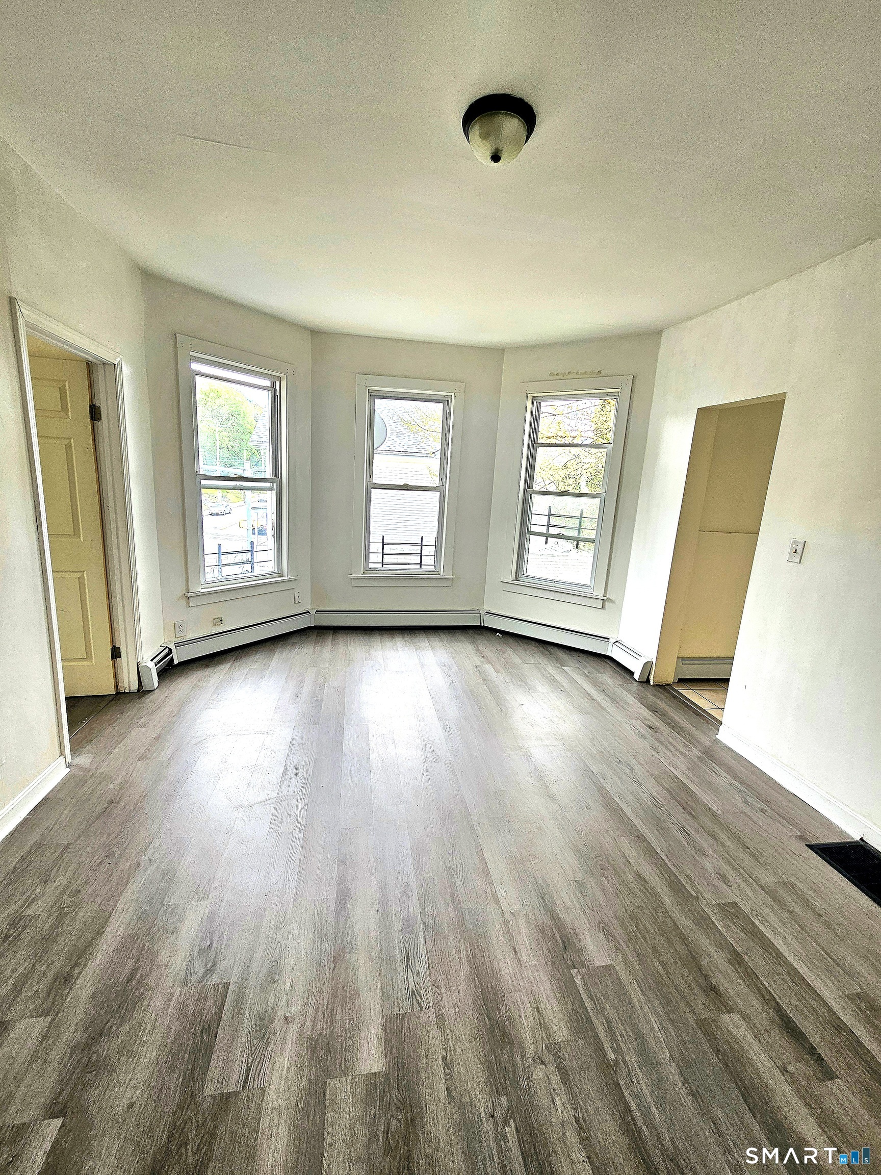 141 Crown Street, Unit 2 Meriden, CT 06450 - Photo 4 of 8 a view of an empty room with wooden floor and a window