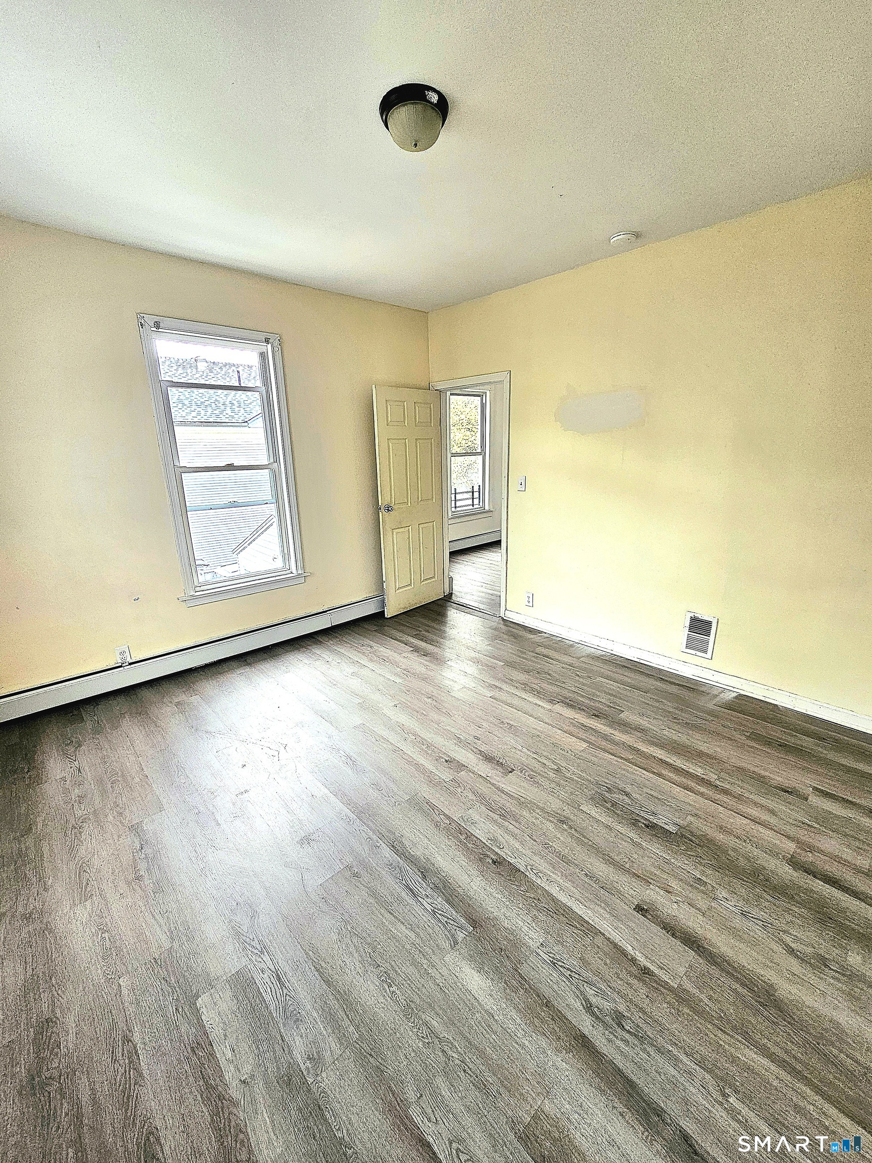 141 Crown Street, Unit 2 Meriden, CT 06450 - Photo 5 of 8 a view of an empty room with wooden floor and a window