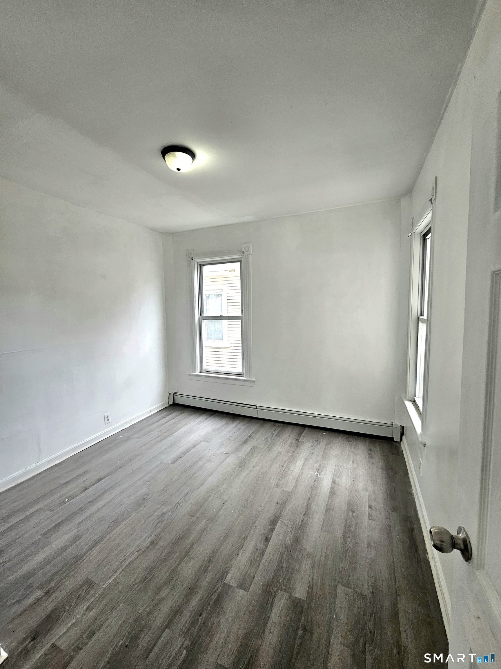 141 Crown Street, Unit 2 Meriden, CT 06450 - Photo 8 of 8 an empty room with wooden floor and windows