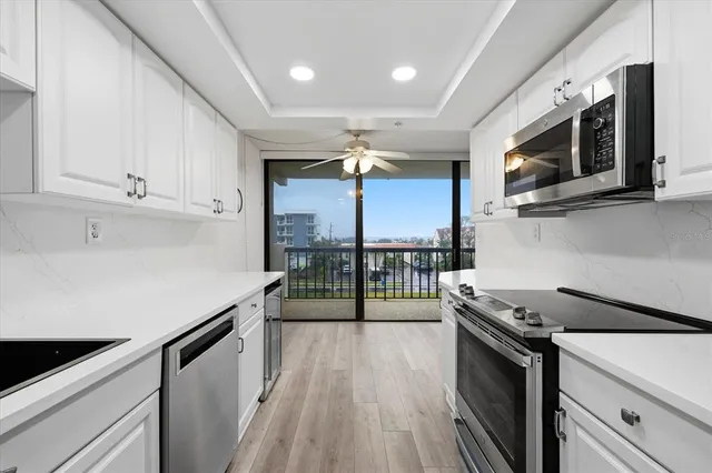 a kitchen with stainless steel appliances a sink stove and cabinets