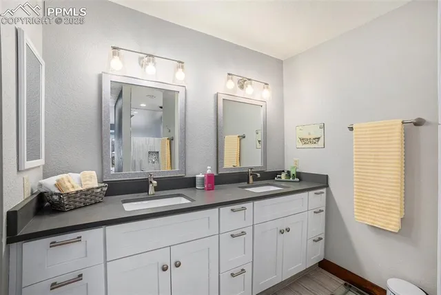 a bathroom with double sink and a mirror
