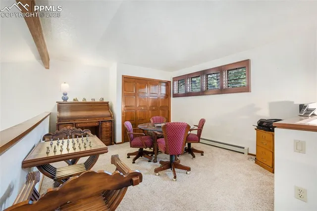 a view of a workspace with furniture and a window