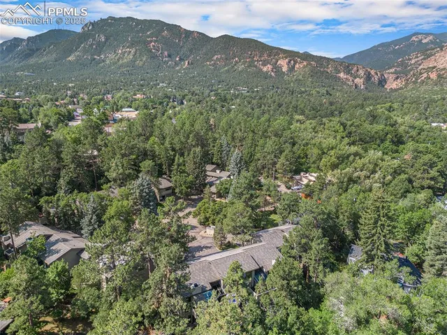 an aerial view of residential houses with outdoor space and trees