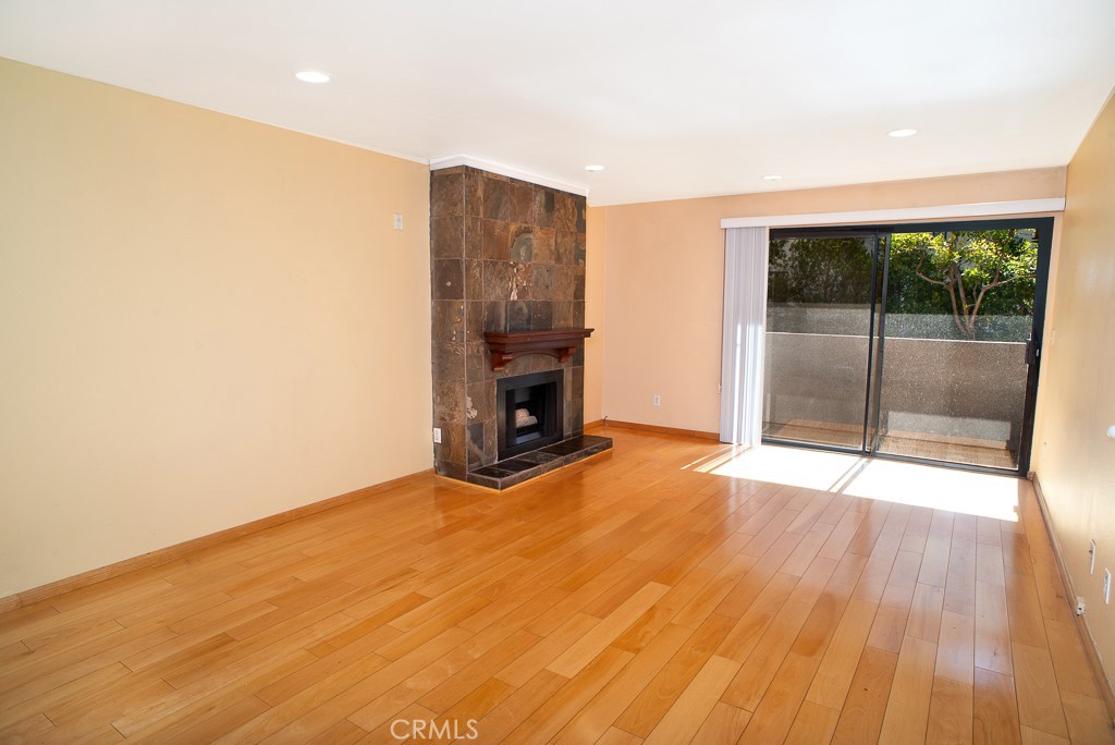 1940 Highland Avenue, Unit 10 Los Angeles, CA 90068 - Photo 6 of 22 an empty room with wooden floor and a fireplace