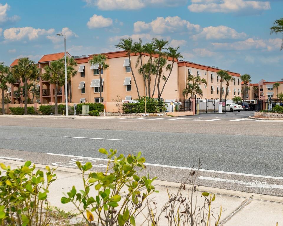 8911 Blind Pass Road, Unit 220 St. Pete Beach, FL 33706 - Photo 2 of 67 a view of a street with a building in the background
