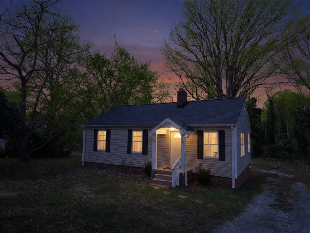 237 Pine Lane Anderson, SC 29621 - Photo 1 of 23 A charming single-story home with a well-lit entryway, nestled amongst mature trees at twilight.
