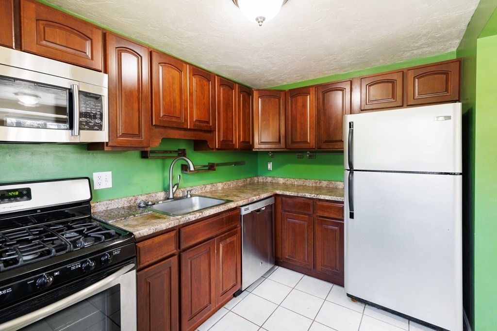 360 Littleton Road, Unit C1 Chelmsford, MA 01824 - Photo 5 of 26 a kitchen with a refrigerator and a sink