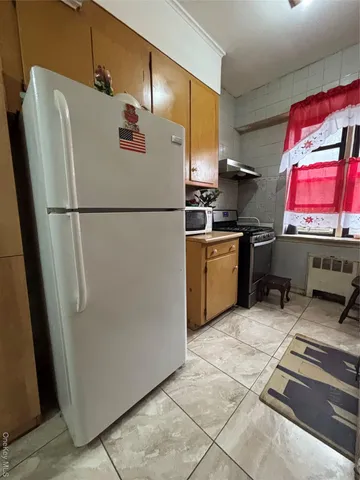 a view of a hallway with wooden floor and a bathroom