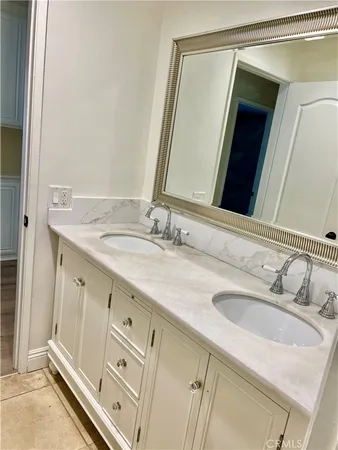 a bathroom with a double vanity sink and a mirror