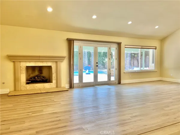 an empty room with wooden floor and a fireplace
