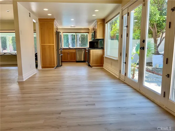 a view of a living room kitchen with hardwood floor and a large window