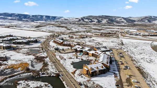an aerial view of residential building and ocean view in back