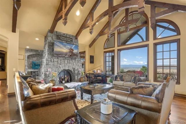 a living room with fireplace furniture and a large window