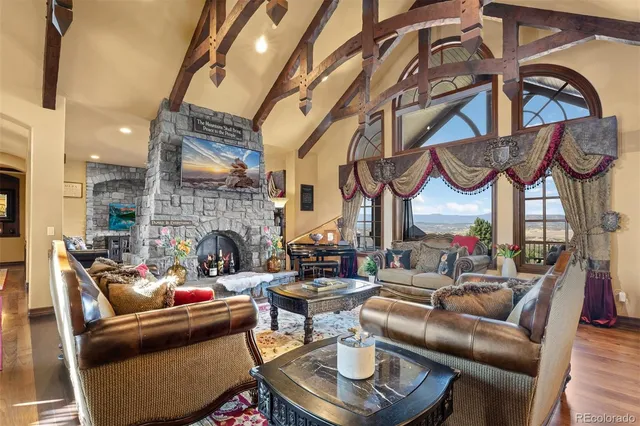 a living room with furniture a fireplace and a chandelier