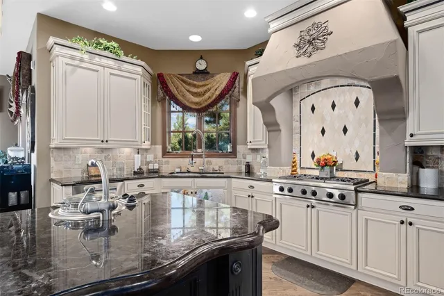 a kitchen with stainless steel appliances granite countertop a sink a stove and cabinets