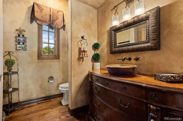 a bathroom with a sink a mirror and wooden floor