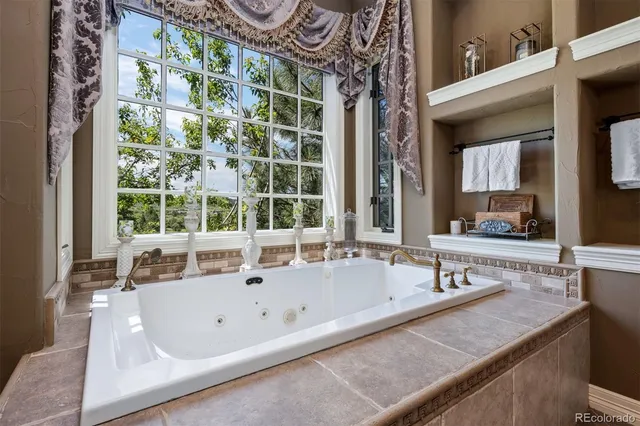 a bathroom with a tub a sink and a window