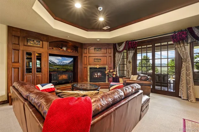 a living room with fireplace furniture and a large window